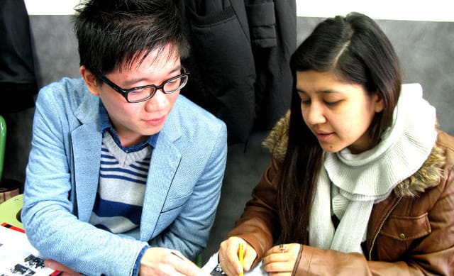 Parella d‘estudiants preparant un text